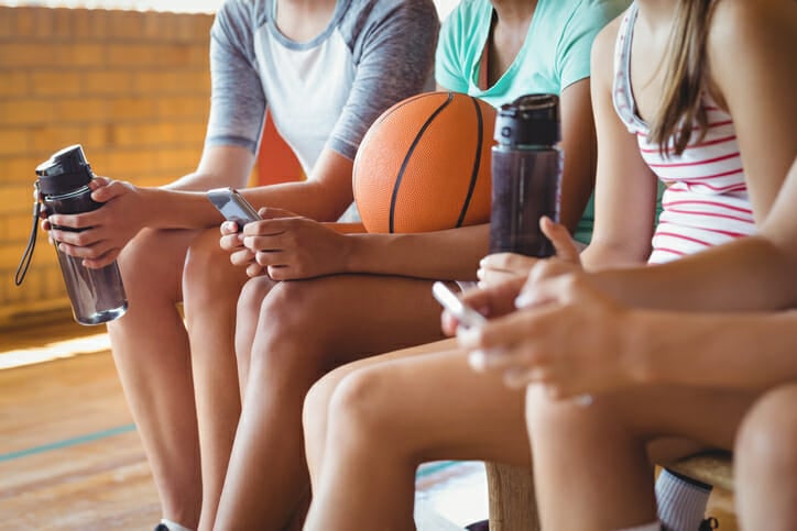 High school kids using mobile phone while relaxing
