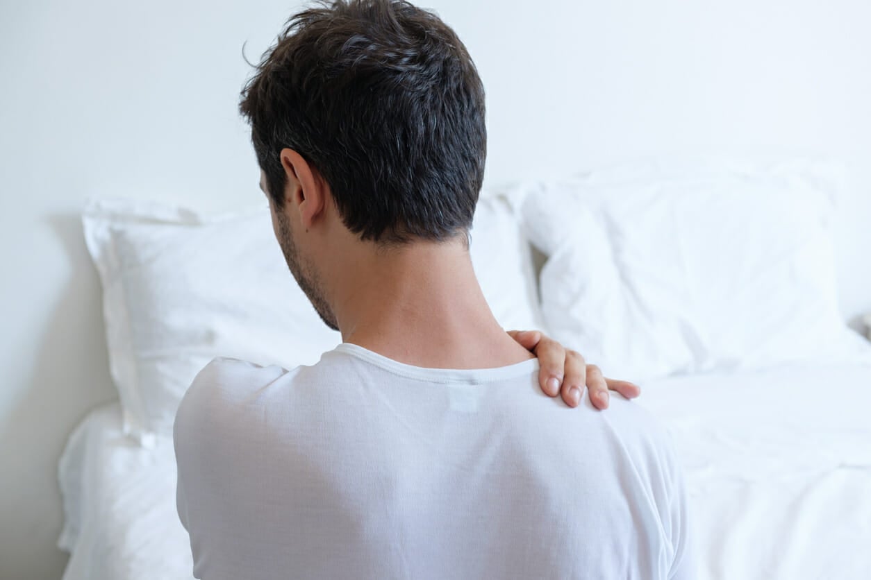 Man feeling back ache in the bed after sleeping