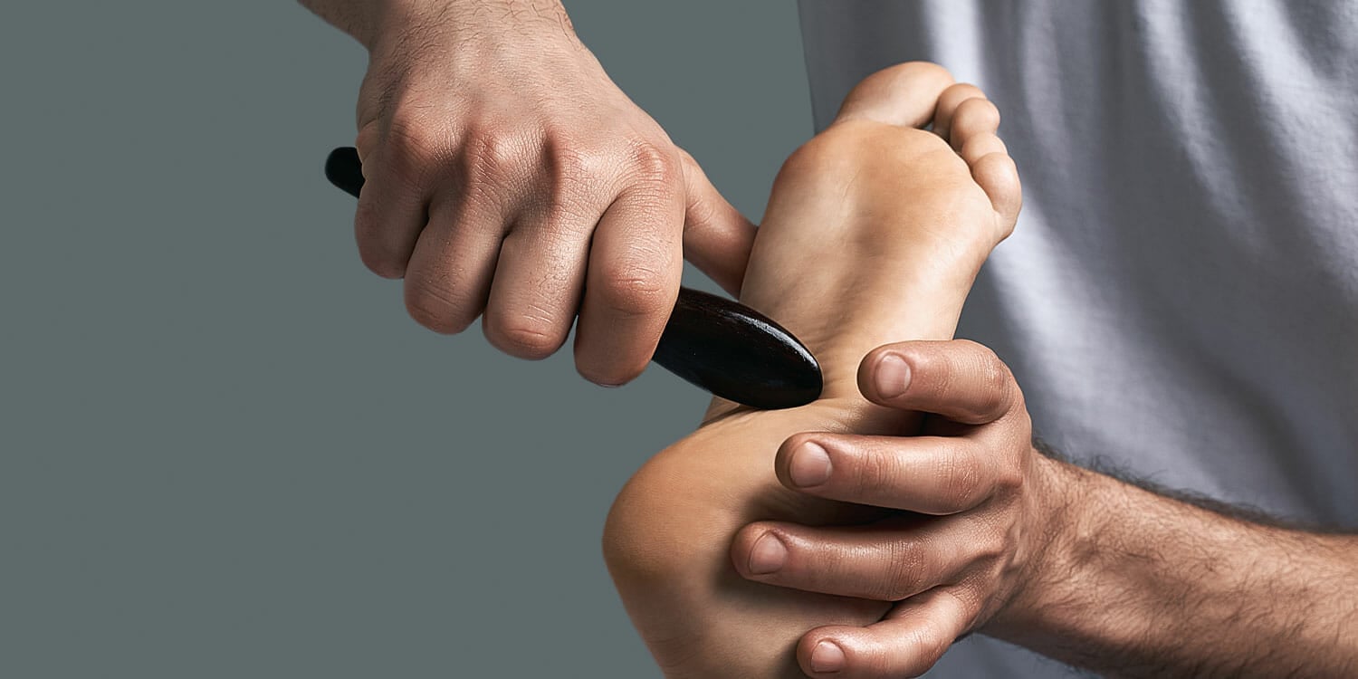 Scraping therapy - Physical therapist uses a small wooden tool to scrape soft tissue, break up scar tissue and promote healing