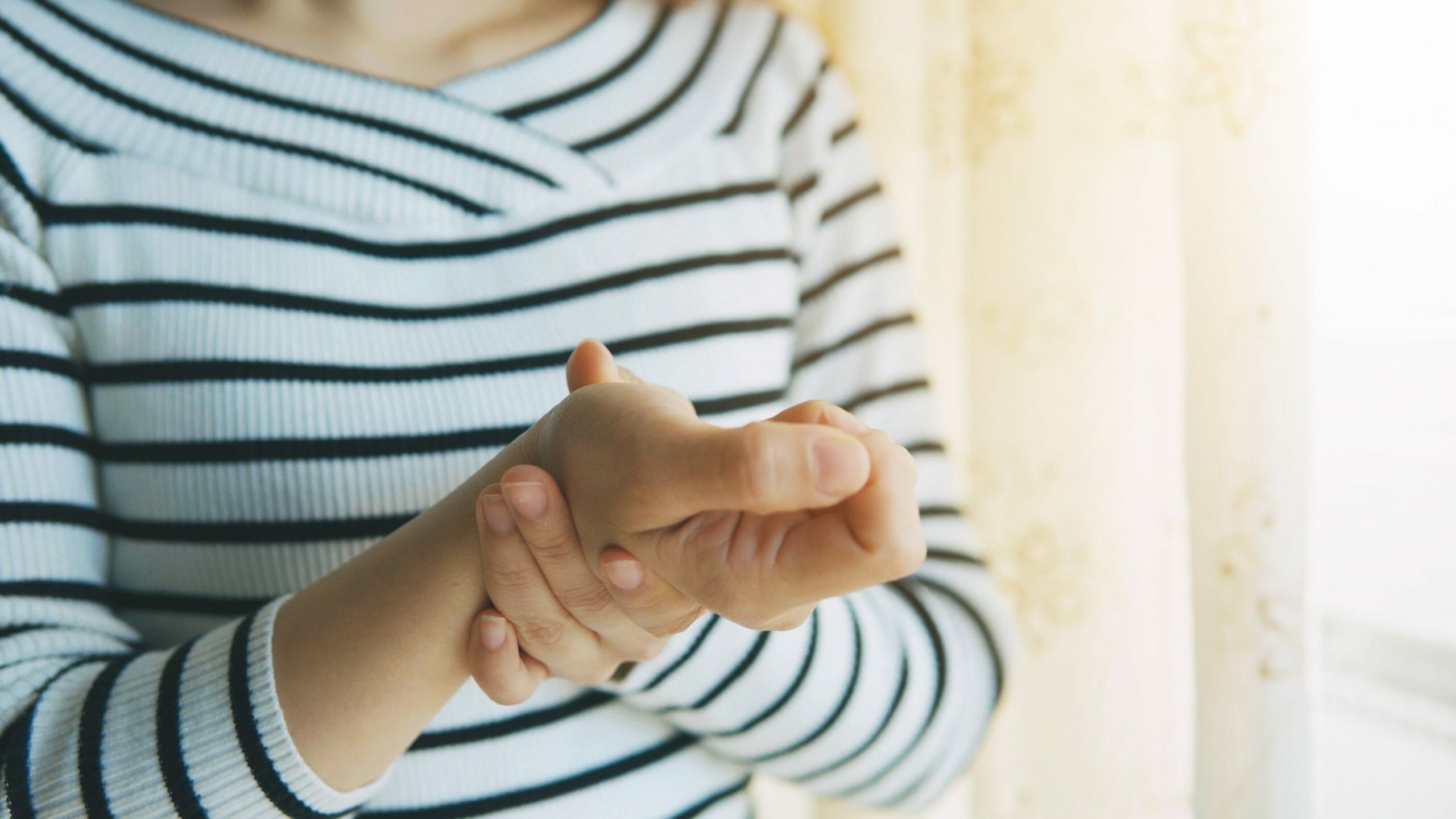 Woman massaging her arthritic hand and wrist