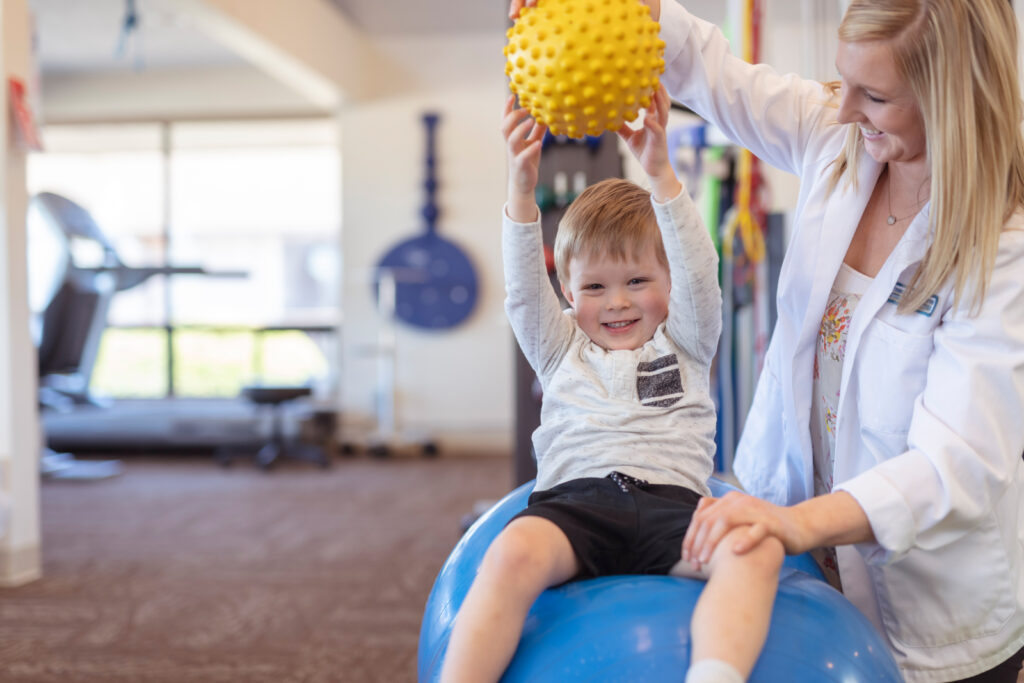 Child receiving pediatric therapy from a physical therapist