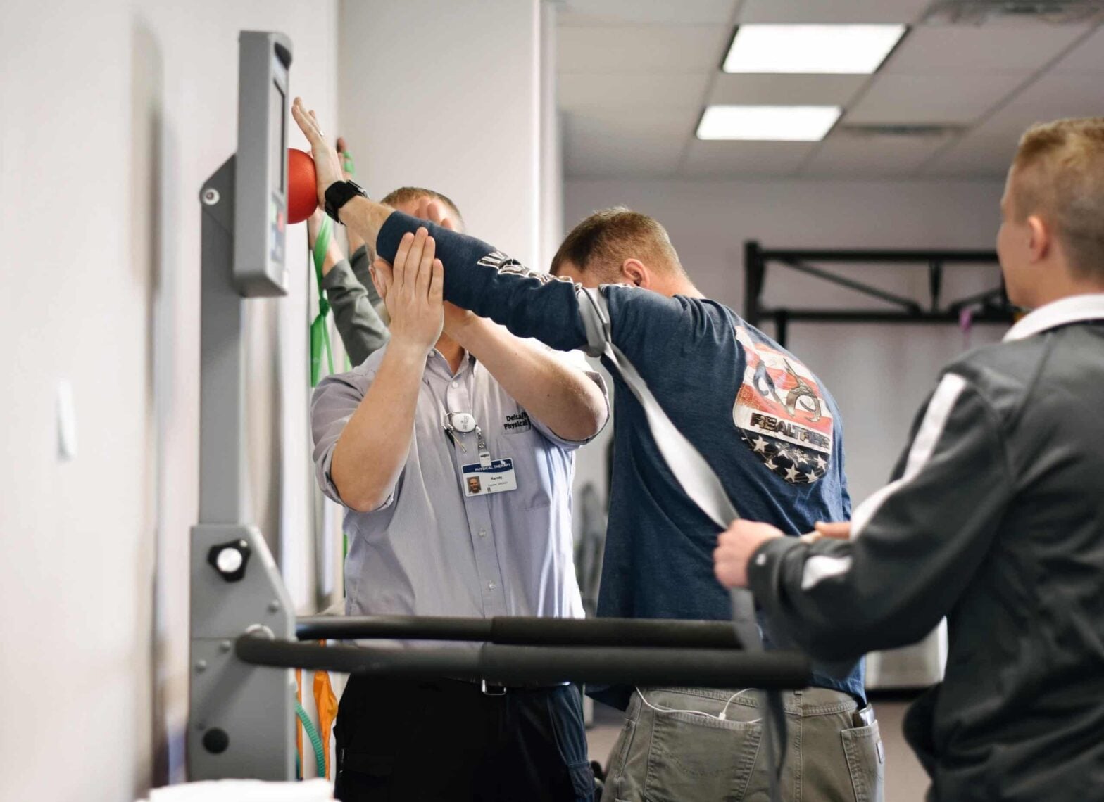 A Mountain Land physical therapist works with a patient in the clinic while a student observes