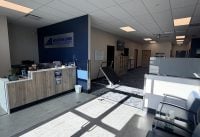Reception area of Mountain Land Physical Therapy with a blue accent wall, sign, and waiting chairs