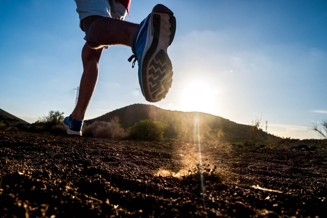 close up of foot of man running alone in the mountains - active and fitness people lifesyle and concept - jogging and loss weight
