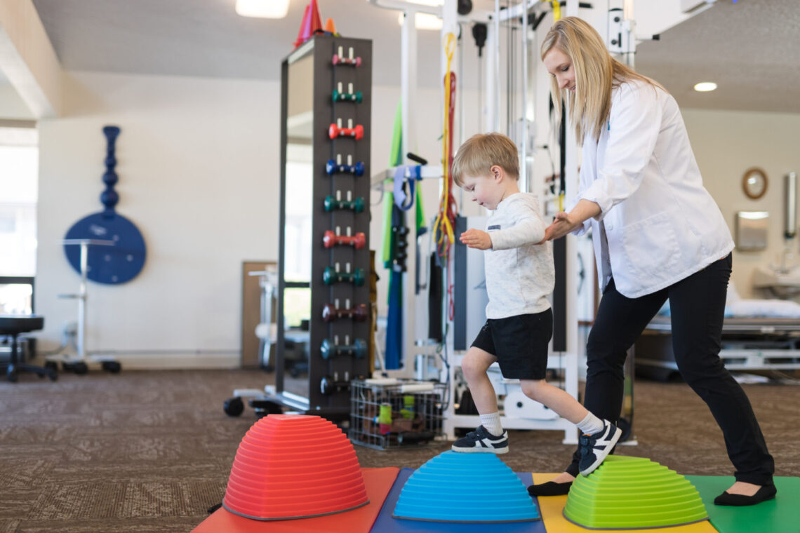 Therapist helping child receive physical therapy