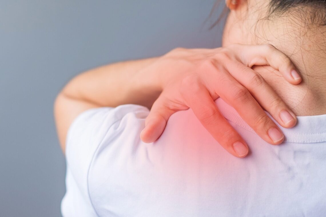 woman with her shoulder sprain, muscle painful during overwork. Girl having body problem after wake up. Shoulder ache, Scapular pain, office syndrome and ergonomic concept